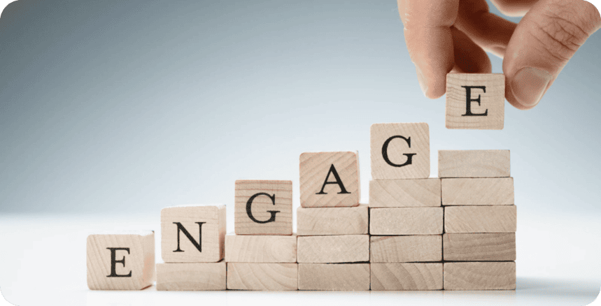 Wooden blocks spelling “ENGAGE”, one being placed on top.